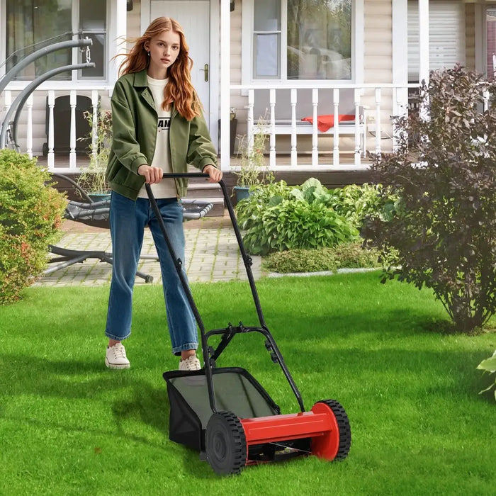Woman using a red lawn mower on a green lawn in front of a house.