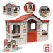 Le Chalet French-inspired playhouse with red roof, grey walls, and window flower boxes.