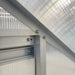 Close-up of aluminium frame and polycarbonate panels on lean-to greenhouse wall