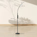 Black floor lamp with measurements on a light wooden floor and white wall background