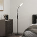 Floor lamp in a bedroom setting with a bed and dresser.