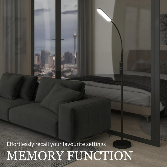 Modern living room with a dark gray sofa and floor lamp, featuring a cityscape view.