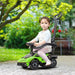 Toddler on green ride-on car with push handle in garden setting