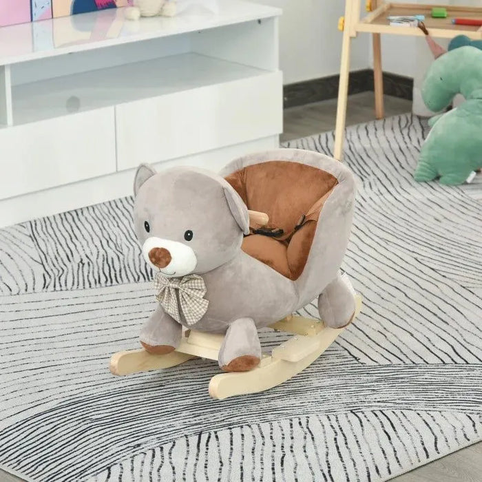 Grey plush bear rocking horse with bow on a striped rug in a child's playroom