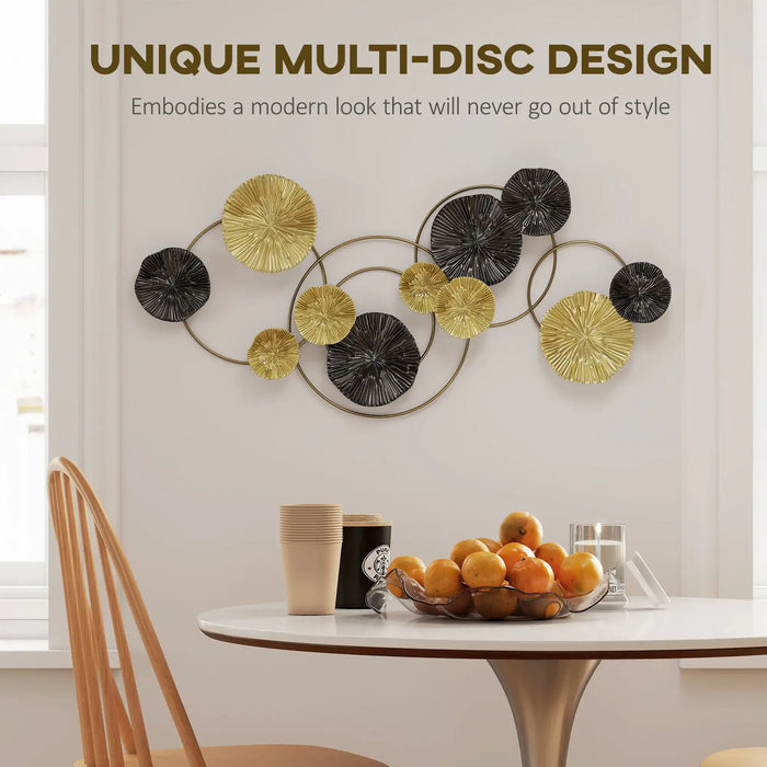 Decorative wall art with gold and black discs above a dining table with fruit and cups.