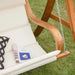 teak larch wood loveseat swing chair with cream cushion and pillow on grass