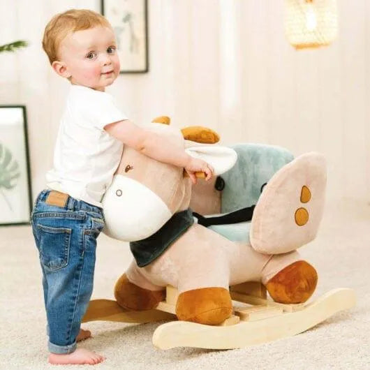Toddler with plush giraffe rocker toy featuring soft padded seat and wooden base