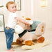 Toddler with plush giraffe rocker toy featuring soft padded seat and wooden base