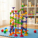 Colorful marble run toy set on play mat in bright children’s playroom with shelves and books