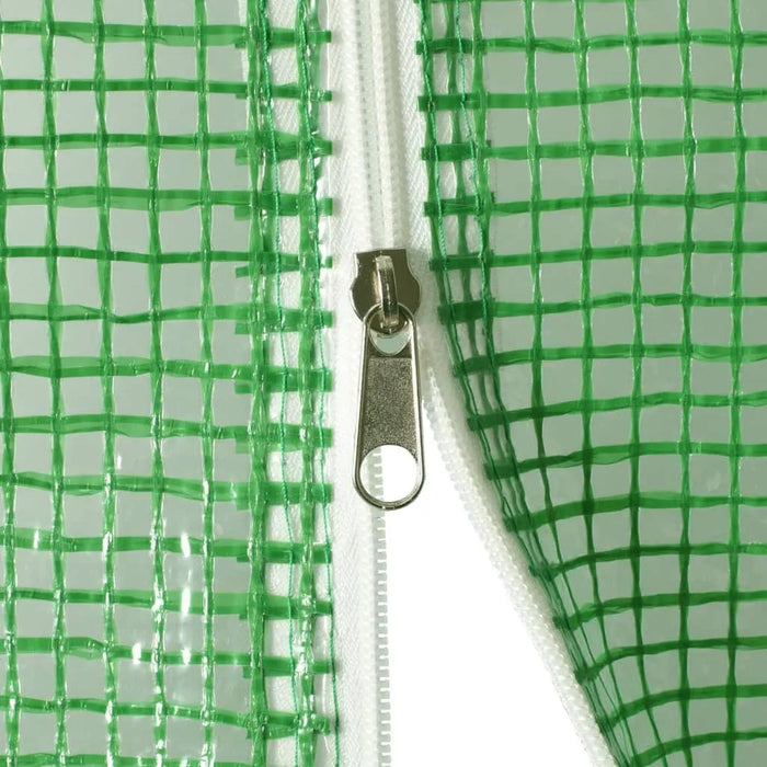 Close-up of green mesh greenhouse cover with white zipper and metal pull tab