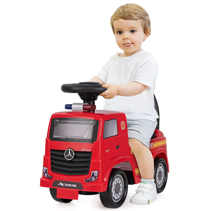 Child playing with a red toy truck on a white background