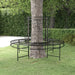 Black metal round tree bench with decorative wrap-around design in a garden setting
