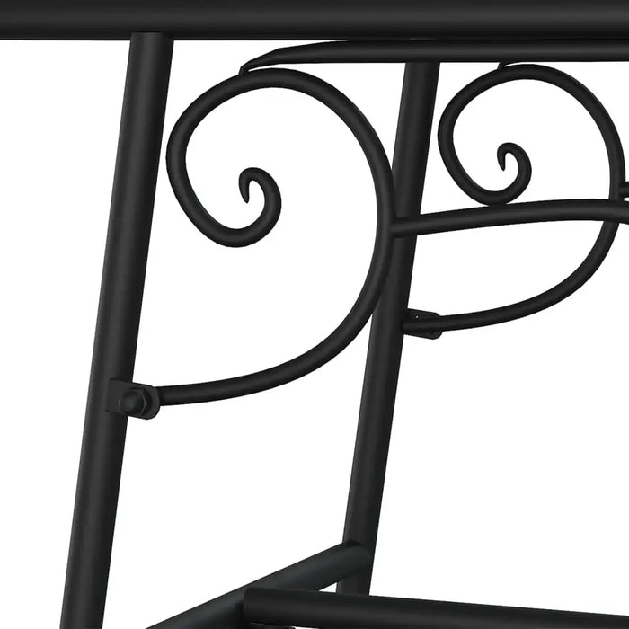 Close-up of black metal circular outdoor bench with decorative scrollwork, tree surround design