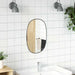 Bathroom with white tiled walls, a round mirror, and a sink.