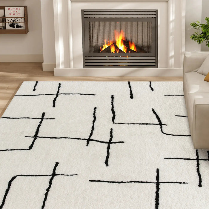 Living room with a white rug featuring black abstract patterns, a fireplace, and a couch.