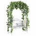 Outdoor antique white garden bench with decorative iron frame, climbing green ivy, and light pink flowers