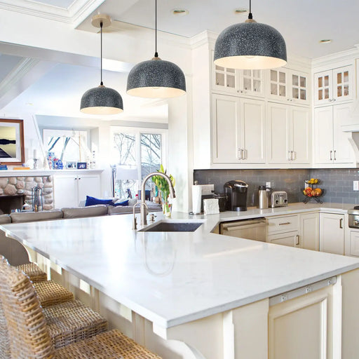 Modern kitchen with white countertops, gray pendant lights, and a large island.