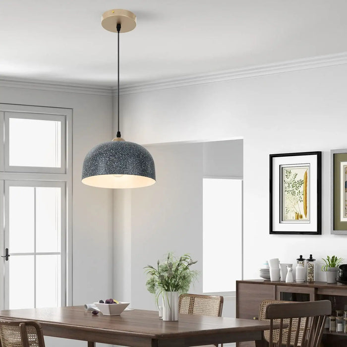 Modern pendant light hanging above a dining table in a bright room with decor elements.