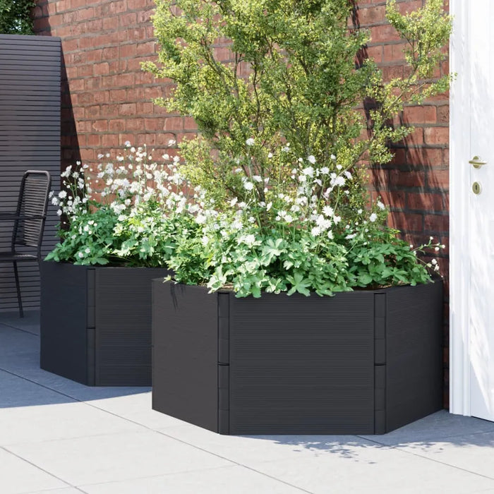 Anthracite modular raised garden planters with white flowers and greenery against a brick wall on patio