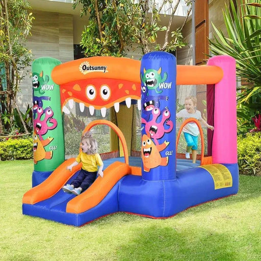 Kids playing in Outsunny monster inflatable bouncy castle with slide and basketball hoop outdoors