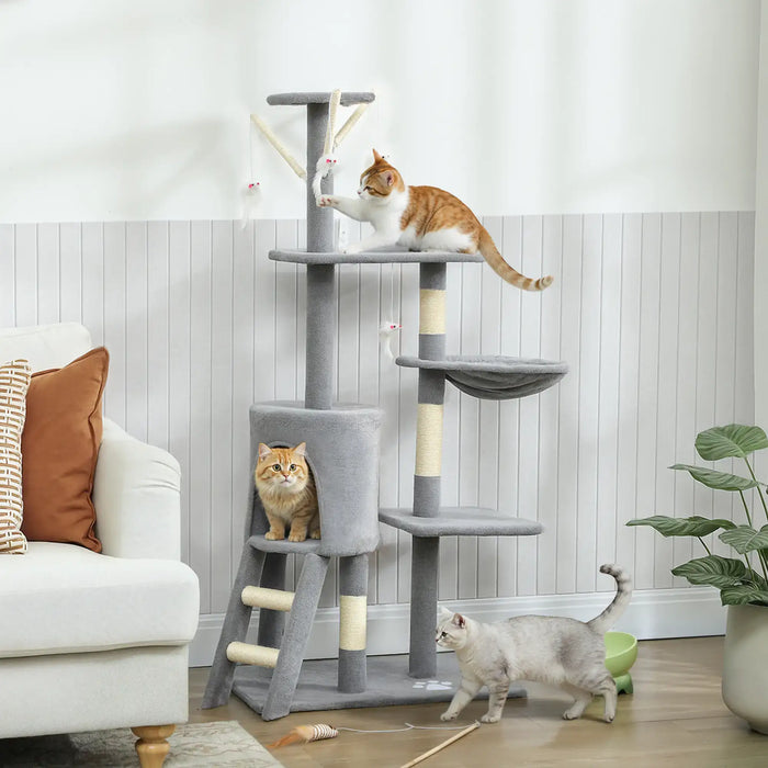 Three cats playing on and around a gray multi-level cat tree in a cozy living room