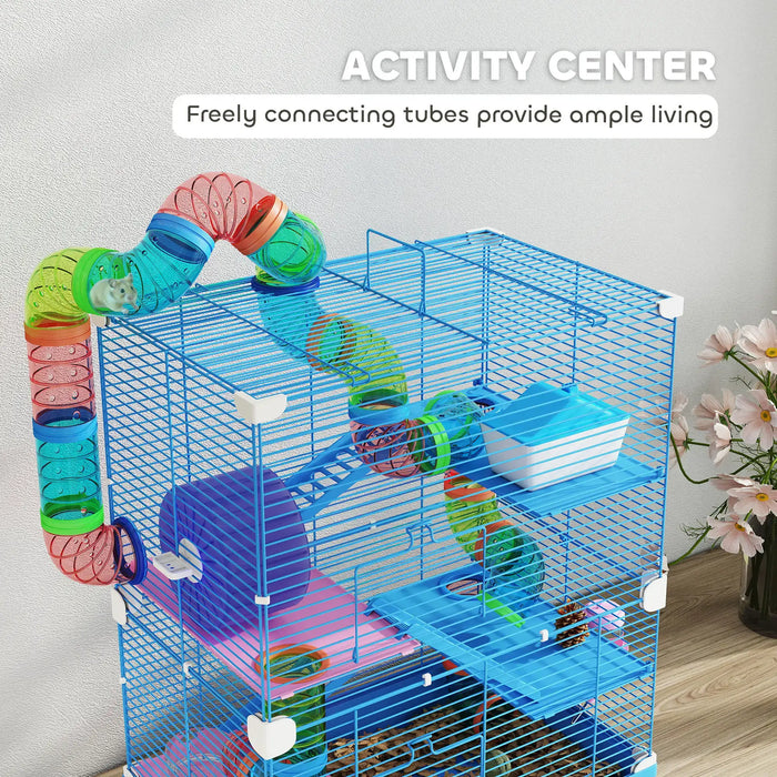 Blue wire hamster cage with colorful connecting tubes, wheel, platform, and food dish on wooden surface