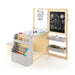 Children's art desk with drawing materials and storage shelves on a white background
