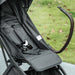 Close-up of a black stroller seat with a blurred grass background