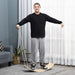 Man using natural beech wood wobble balance board with ropes in modern living room