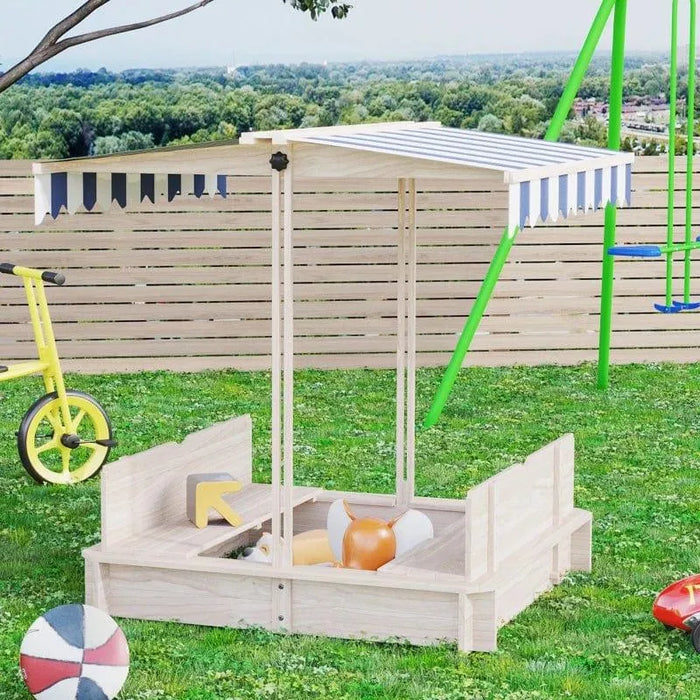 Natural wood sandbox with benches and striped canopy in grassy backyard playground