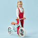 Child with blue no-pedal balance bike, adjustable seat, metal frame, on light blue background