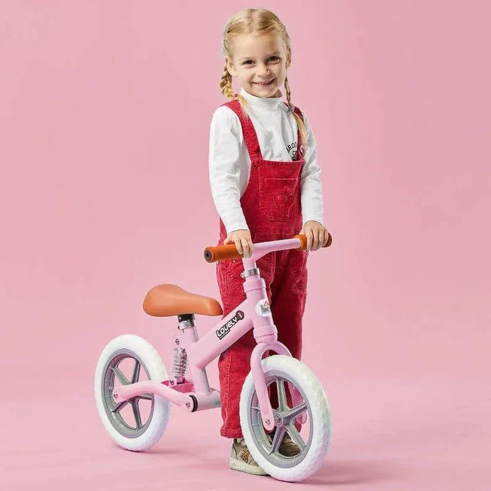 Child with pink balance bike featuring adjustable seat and lightweight metal frame