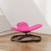 Pink and black chair on a wooden floor with a white wall in the background