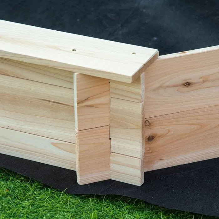 Close-up view of a wooden corner joint on an Outsunny kids sandbox with cover, showing precise craftsmanship with interlocking parts on artificial grass.