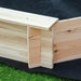 Close-up view of a wooden corner joint on an Outsunny kids sandbox with cover, showing precise craftsmanship with interlocking parts on artificial grass.