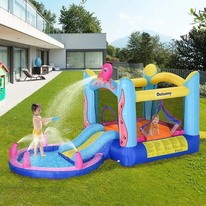 Kids playing on Outsunny octopus inflatable bouncy castle with slide and water sprayer in a yard