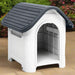 Grey and white outdoor dog house with ventilation and raised floor on patio