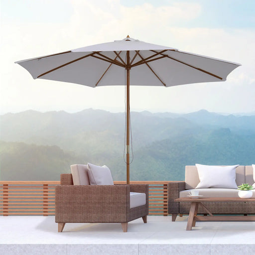 Outdoor patio set with umbrella and furniture against a mountainous background