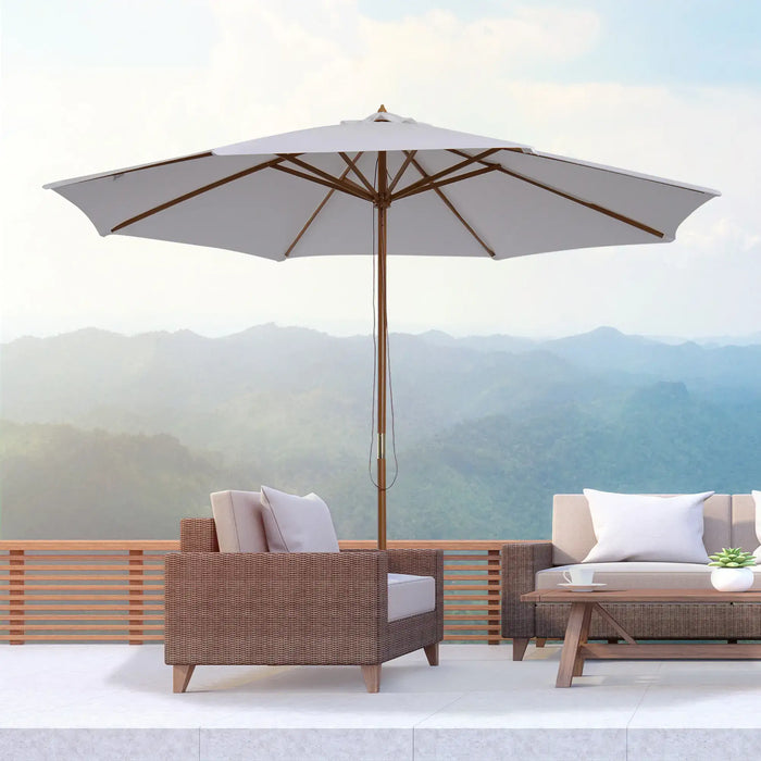 Outdoor patio set with umbrella and furniture against a mountainous background