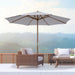 Outdoor patio set with umbrella and furniture against a mountainous background