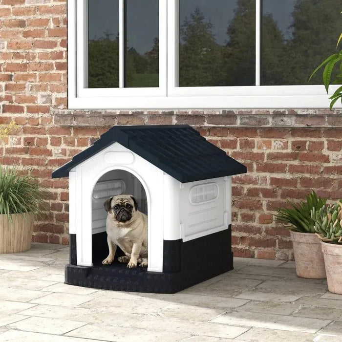 Pug in outdoor plastic dog kennel with slanted roof and ventilated windows on patio