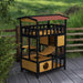 Outdoor wooden cat house with four levels, suspension bridge, and balcony on a patio