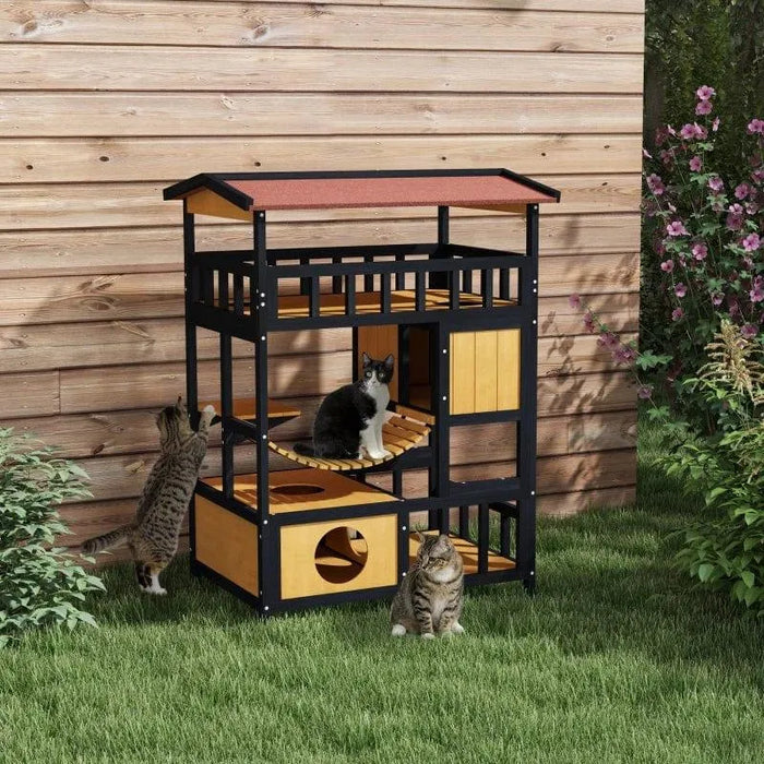 Outdoor wooden cat house with four levels, balcony, bridge and three cats on grass