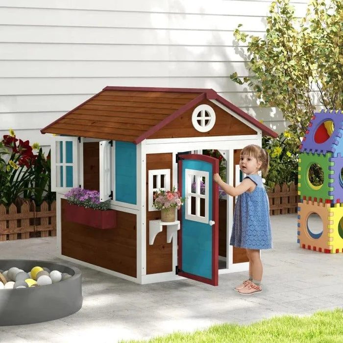 Child playing in outdoor wooden garden playhouse with blue door and flower boxes
