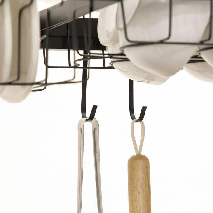 Kitchen utensils hanging from a magnetic strip on a white background