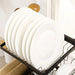 Stack of white plates on a black dish rack in a kitchen setting