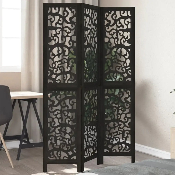 Black three-panel room divider with decorative cut-out patterns in a room setting.
