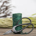 Green jute garden twine and black pruning scissors on wooden table, plant tie kit