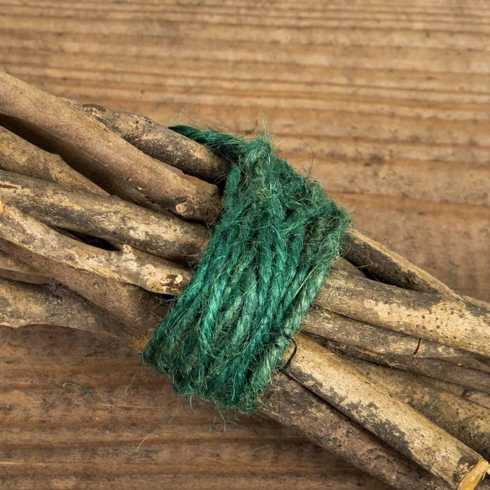 Green jute twine tying bundle of sticks on wooden surface, plant tie gardening kit