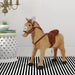 Plush ride-on horse toy with saddle in modern room with striped rug and white table